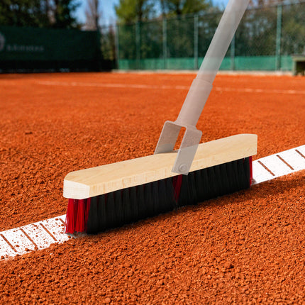 Linienbesen DUAL mit roten und schwarzen Borsten beim Reinigen einer Tennisplatzlinie auf dem Sandplatz