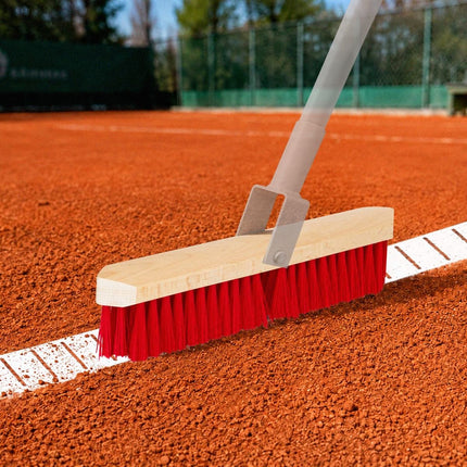 Spitzer Linienbesen mit roten PET-Borsten beim Reinigen einer weißen Tennisplatzlinie auf dem Sandplatz