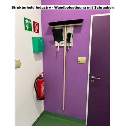 Strukturheld Industry Wandhalter für Besen, Handfeger und Kehrschaufel als robuste Reinigungsstation im öffentlichen Gebäude.